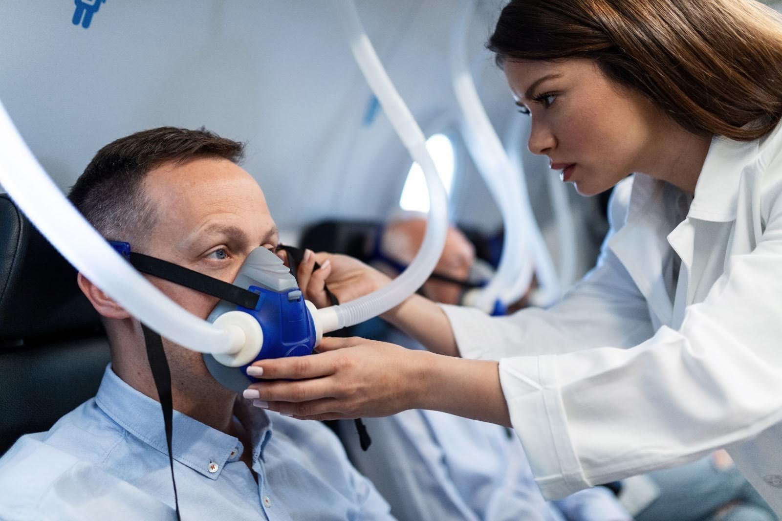 Clinician fitting a sleep apnea breathing mask to a patient