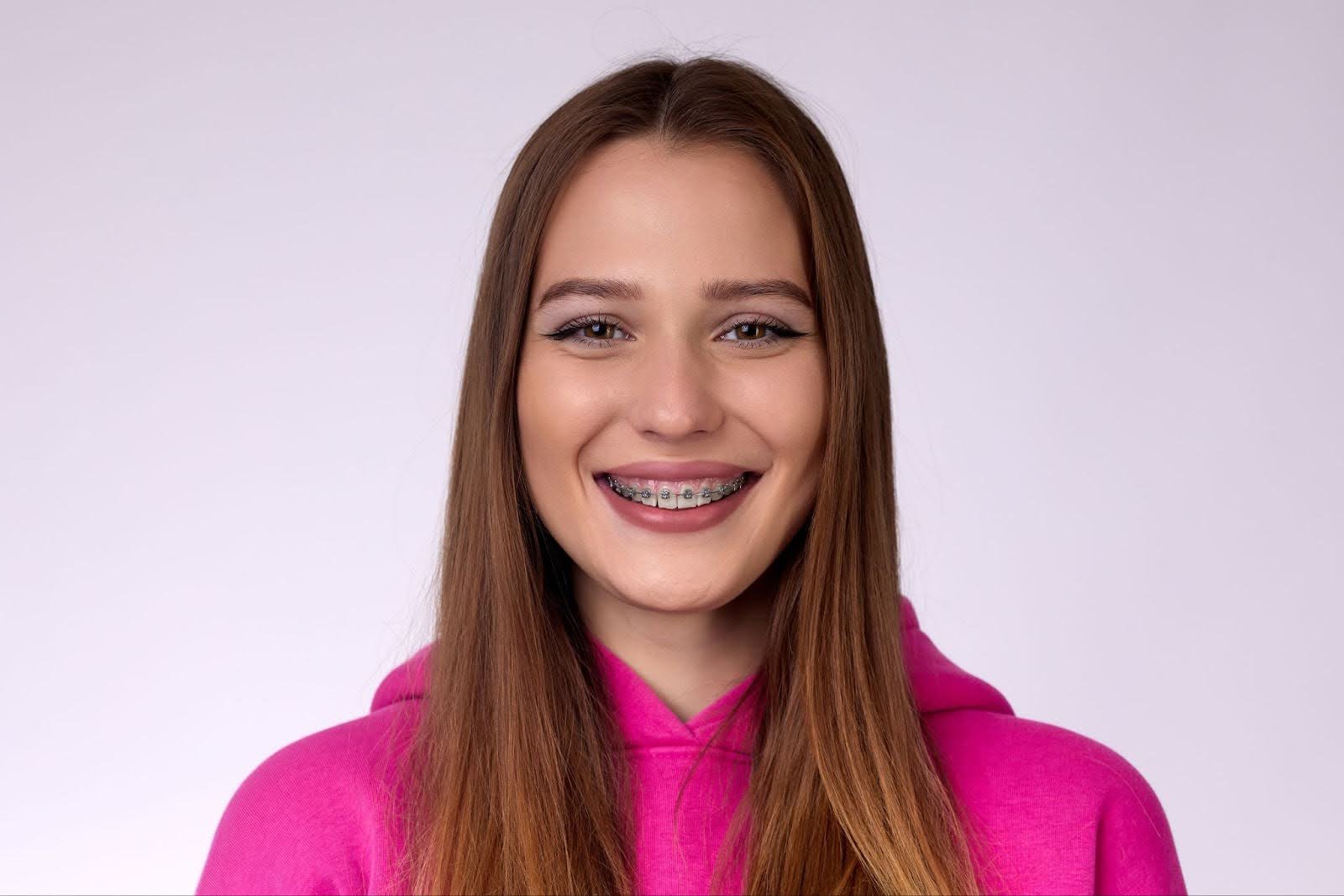 Teenage patient smiling with fixed metal braces