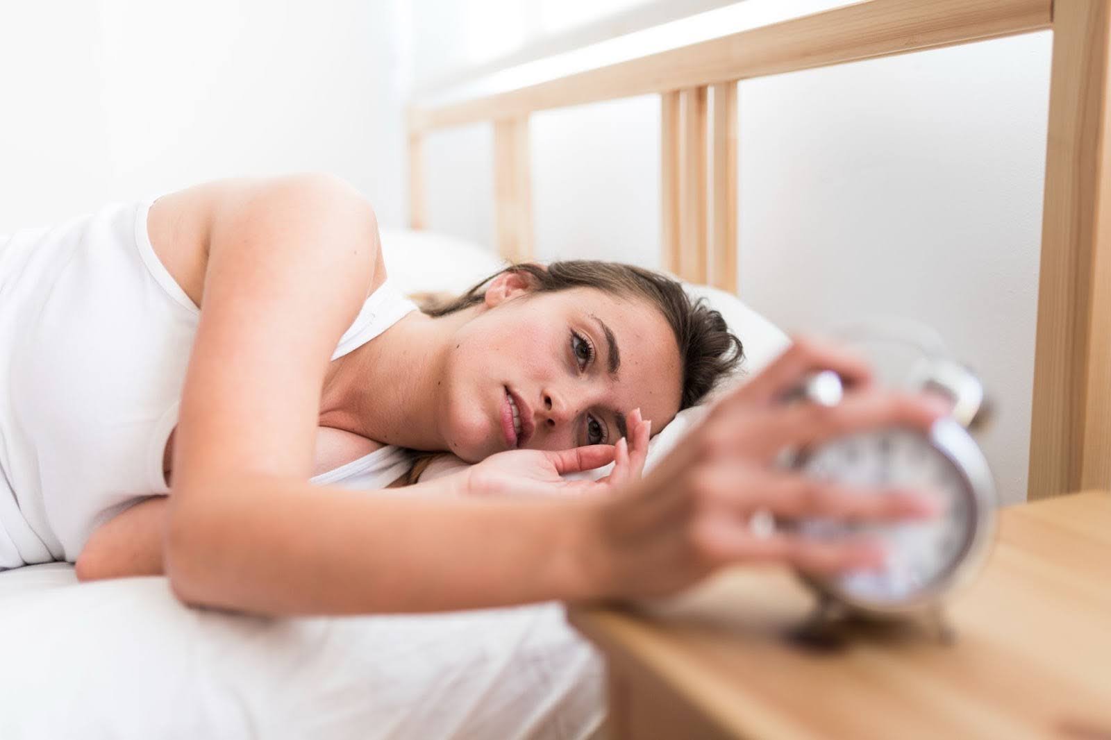 Woman waking up tired after a broken night’s sleep
