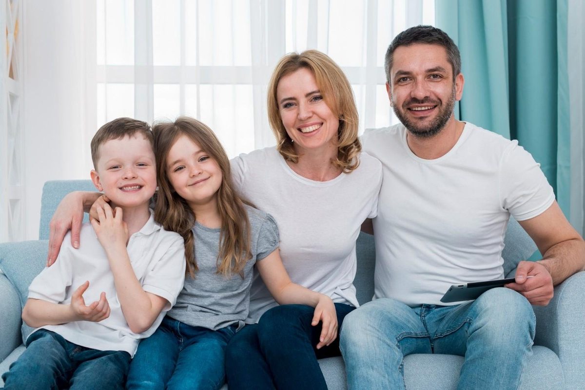 Parents and two children smiling together at home